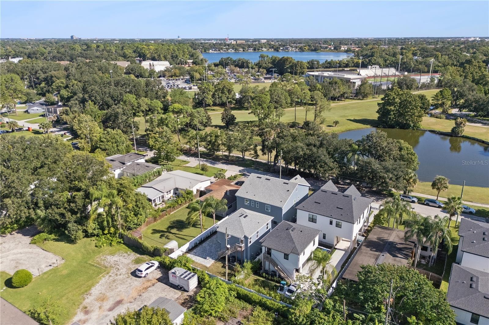 An aerial view shows the home and surrounding neighborhood, with the golf course and pond across the street. - 3456 FAIRWAY LN, ORLANDO