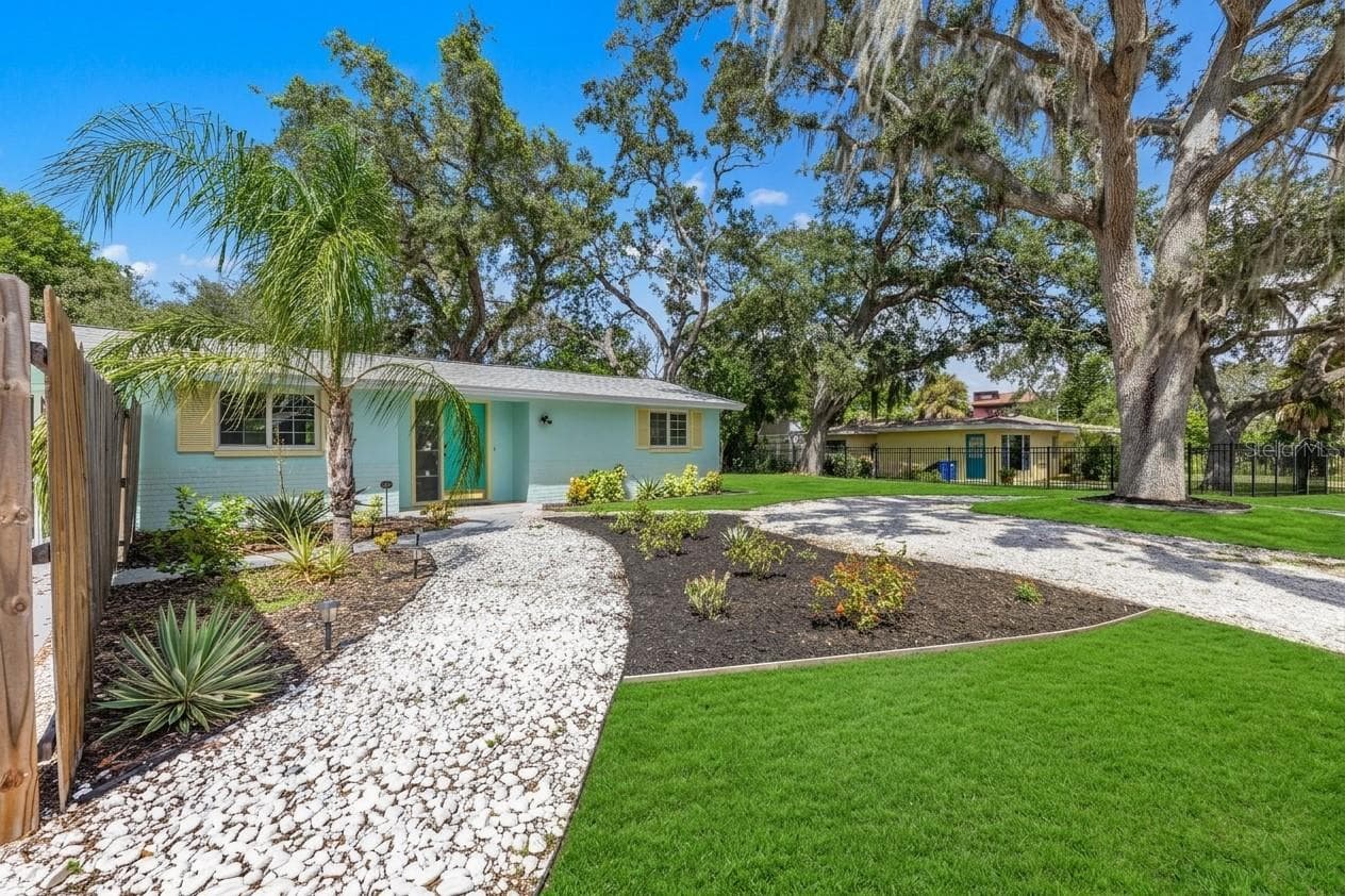 Wide view highlights the home’s spacious .19-acre lot, mature shade trees, tropical landscaping, and generous outdoor space. - 201 SOUTH ST, PALM HARBOR