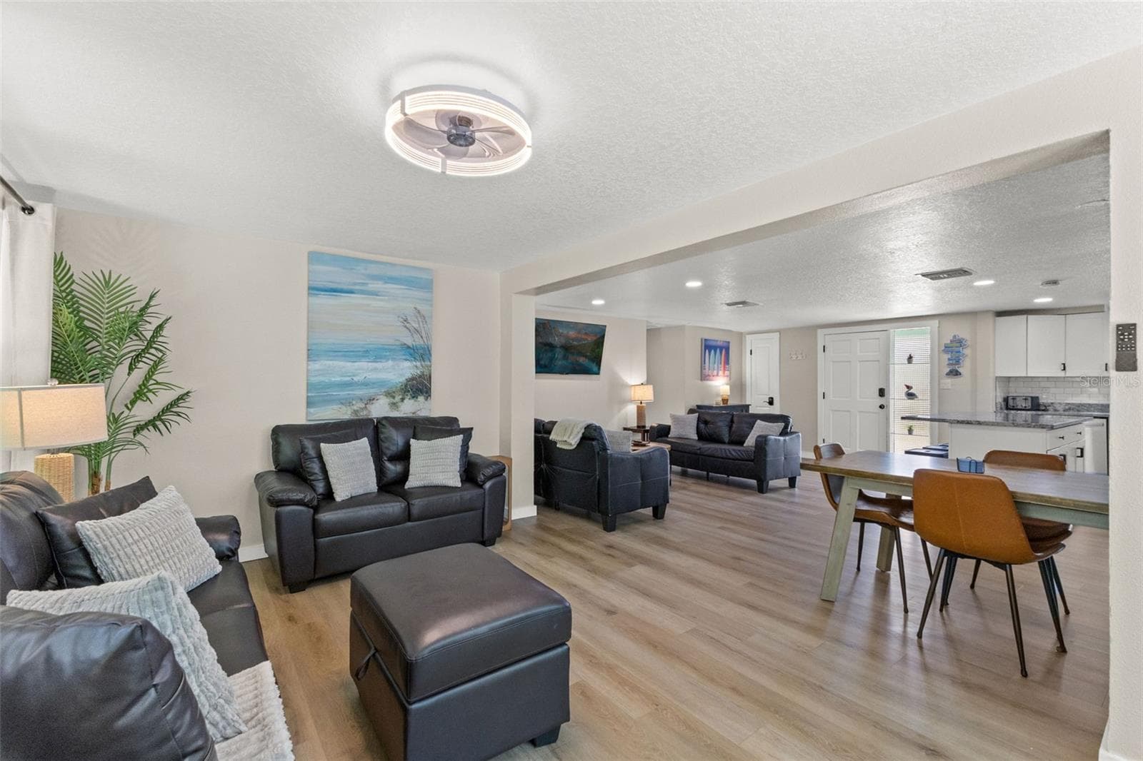 The open floor plan provides multiple gathering spaces with luxury vinyl plank flooring throughout—no carpet. - 201 SOUTH ST, PALM HARBOR