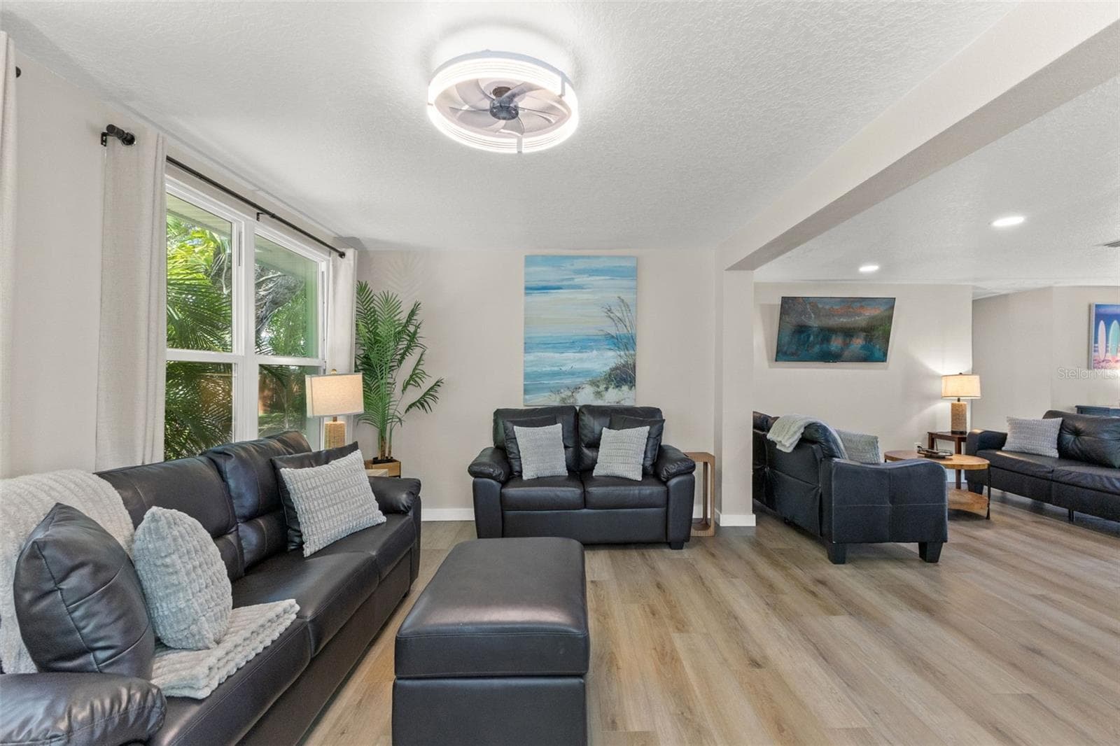 Large windows bring natural light and tropical views into this spacious living area. - 201 SOUTH ST, PALM HARBOR