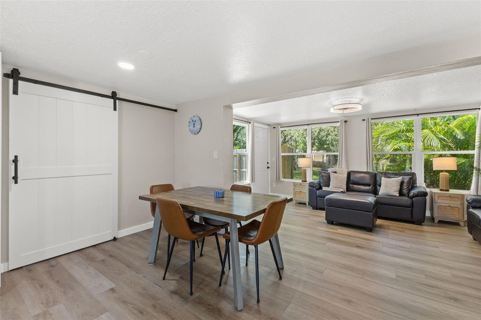 Dedicated dining area sits between the renovated kitchen and living spaces, with a large barn door adding character and function. - 201 SOUTH ST, PALM HARBOR