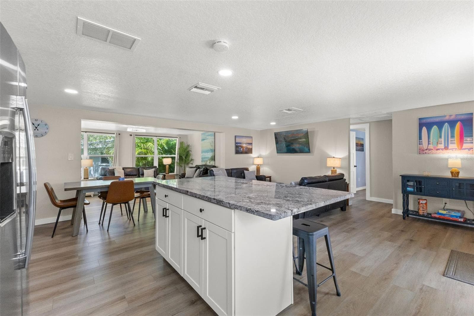 The large kitchen island anchors the open floor plan, connecting the kitchen to the dining and living areas. - 201 SOUTH ST, PALM HARBOR