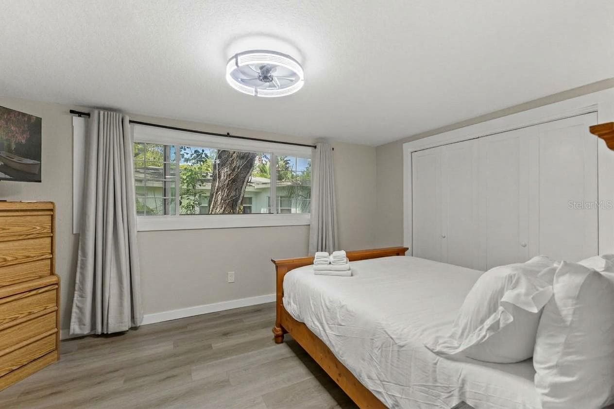 Spacious third bedroom with LVP flooring, modern ceiling fan, and flexible space for guests, a home office, or both. - 201 SOUTH ST, PALM HARBOR