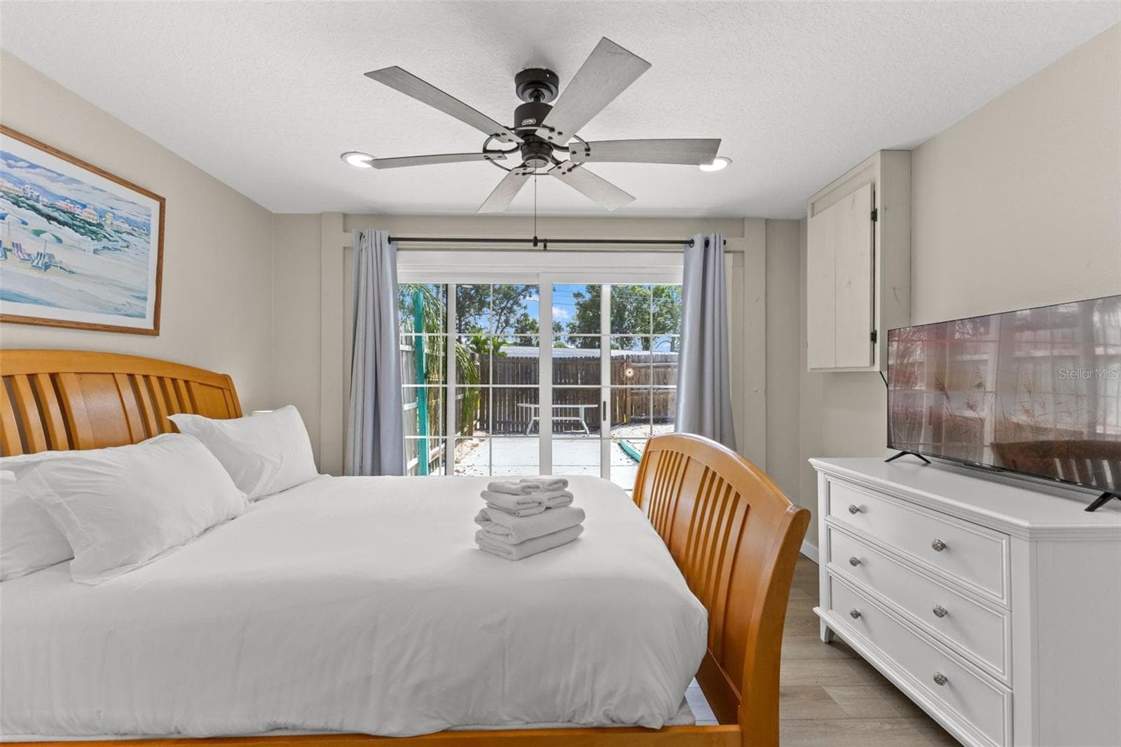 Another view of the owner's bedroom highlights the direct pool access and abundant natural light from the oversized sliding glass doors. - 201 SOUTH ST, PALM HARBOR