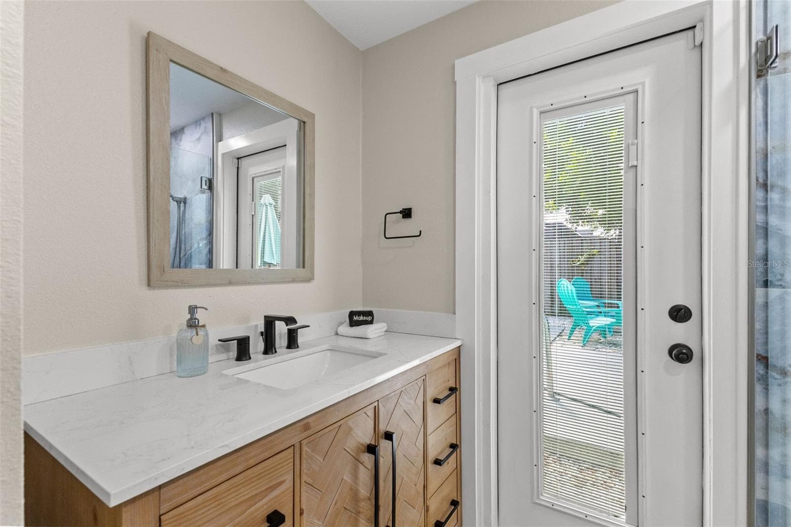 Updated vanity with modern black fixtures and direct exterior access—especially convenient when enjoying the pool. - 201 SOUTH ST, PALM HARBOR