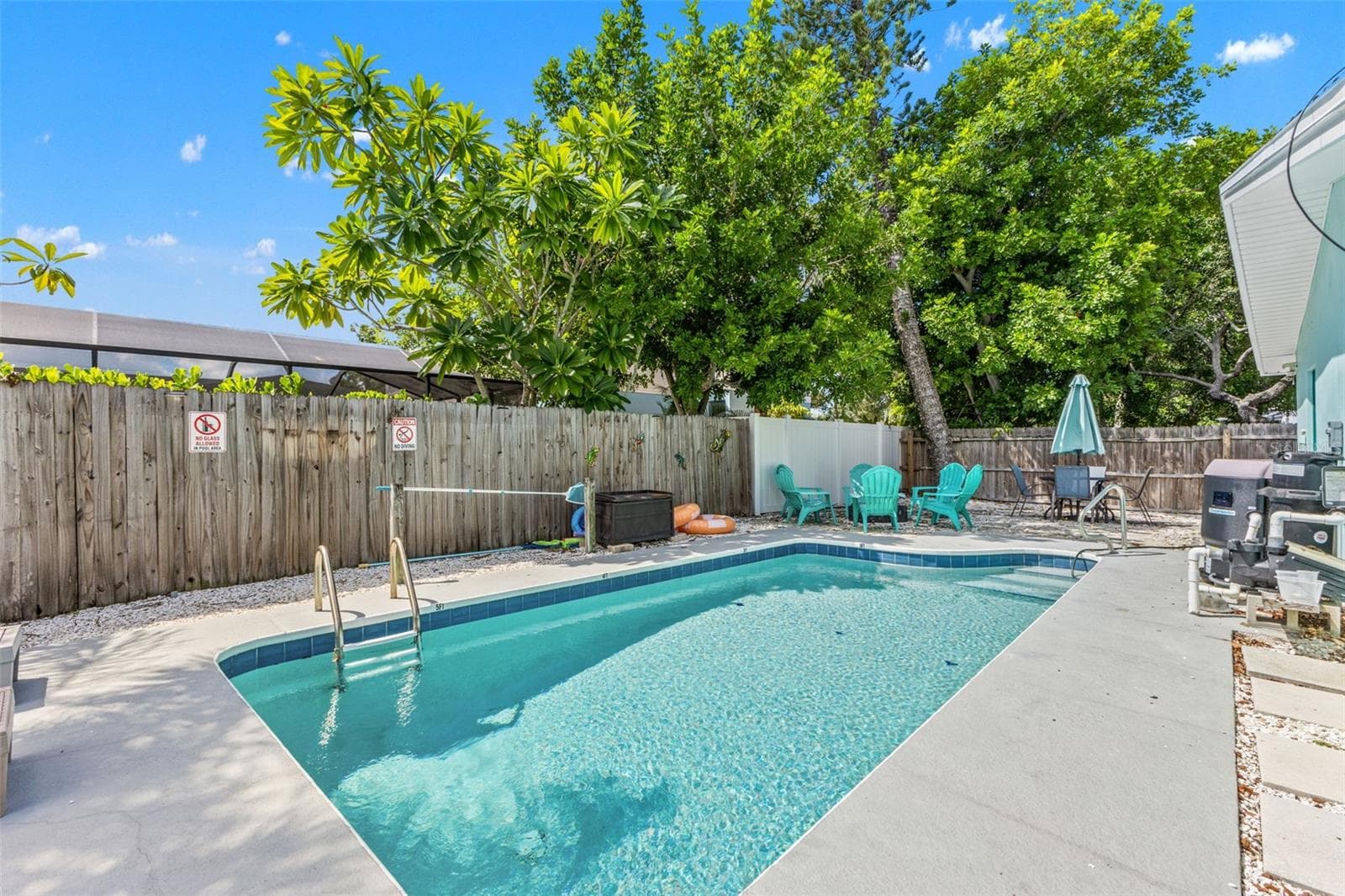 Private heated pool surrounded by mature landscaping and multiple spaces for lounging and relaxing outdoors. - 201 SOUTH ST, PALM HARBOR