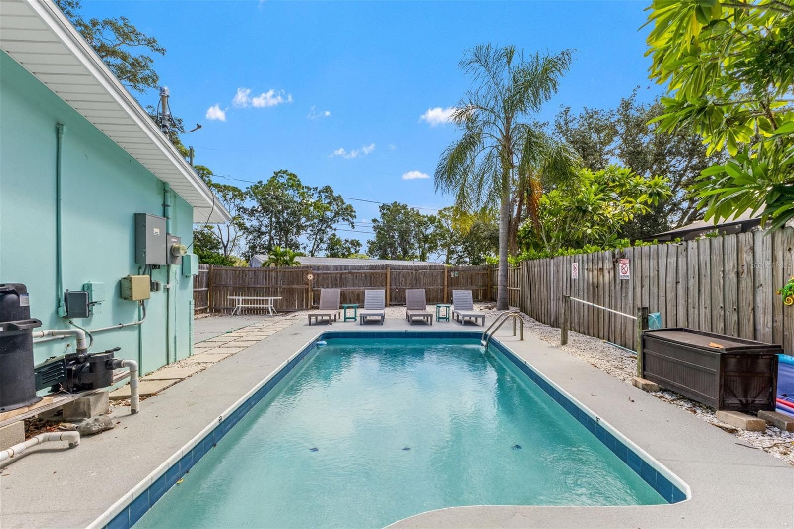 Spacious pool area with plenty of room for lounge chairs, outdoor seating, and entertaining. - 201 SOUTH ST, PALM HARBOR