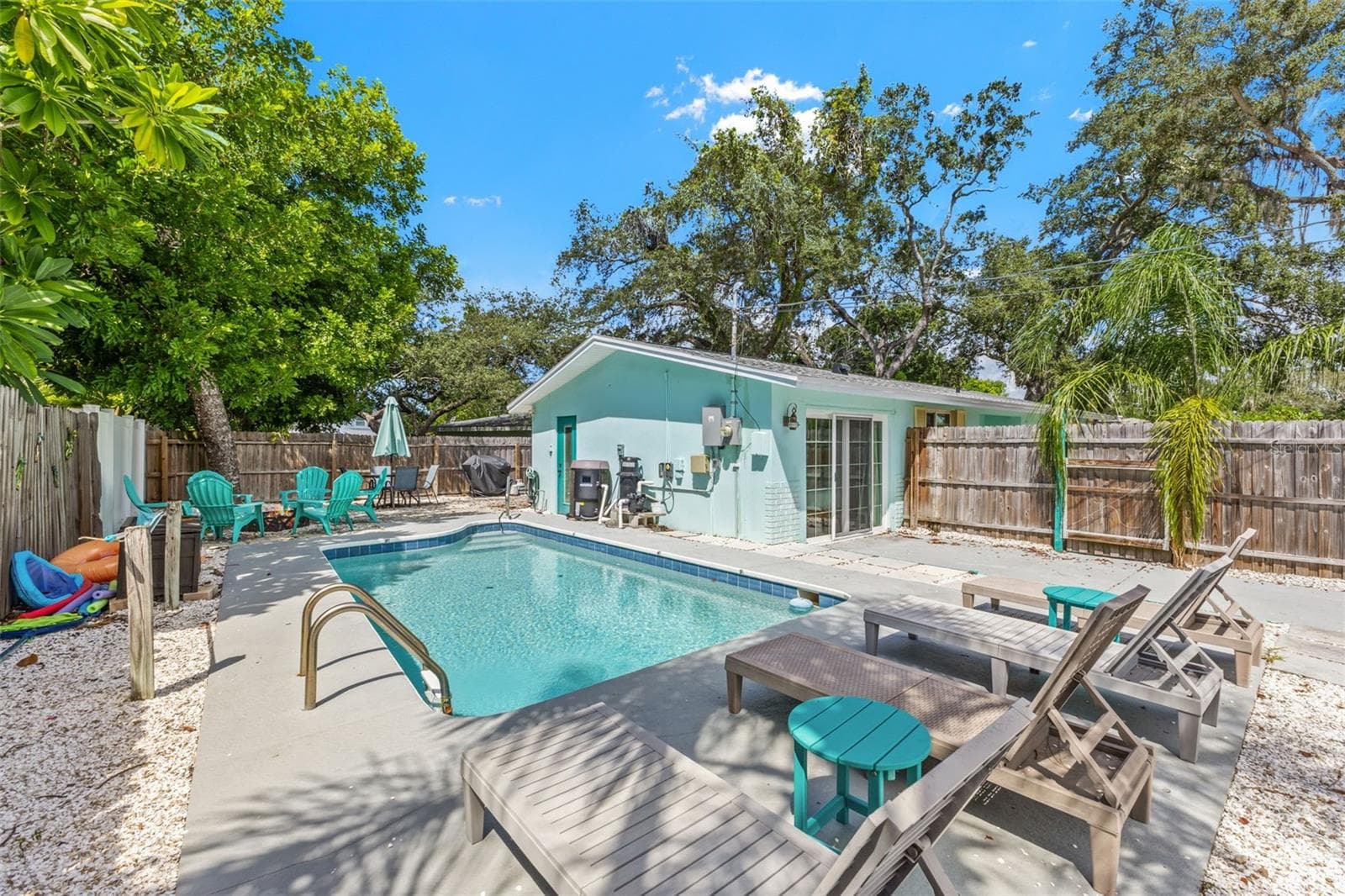 Private pool and patio create an easy outdoor extension of the home, with mature trees providing a natural backdrop. - 201 SOUTH ST, PALM HARBOR
