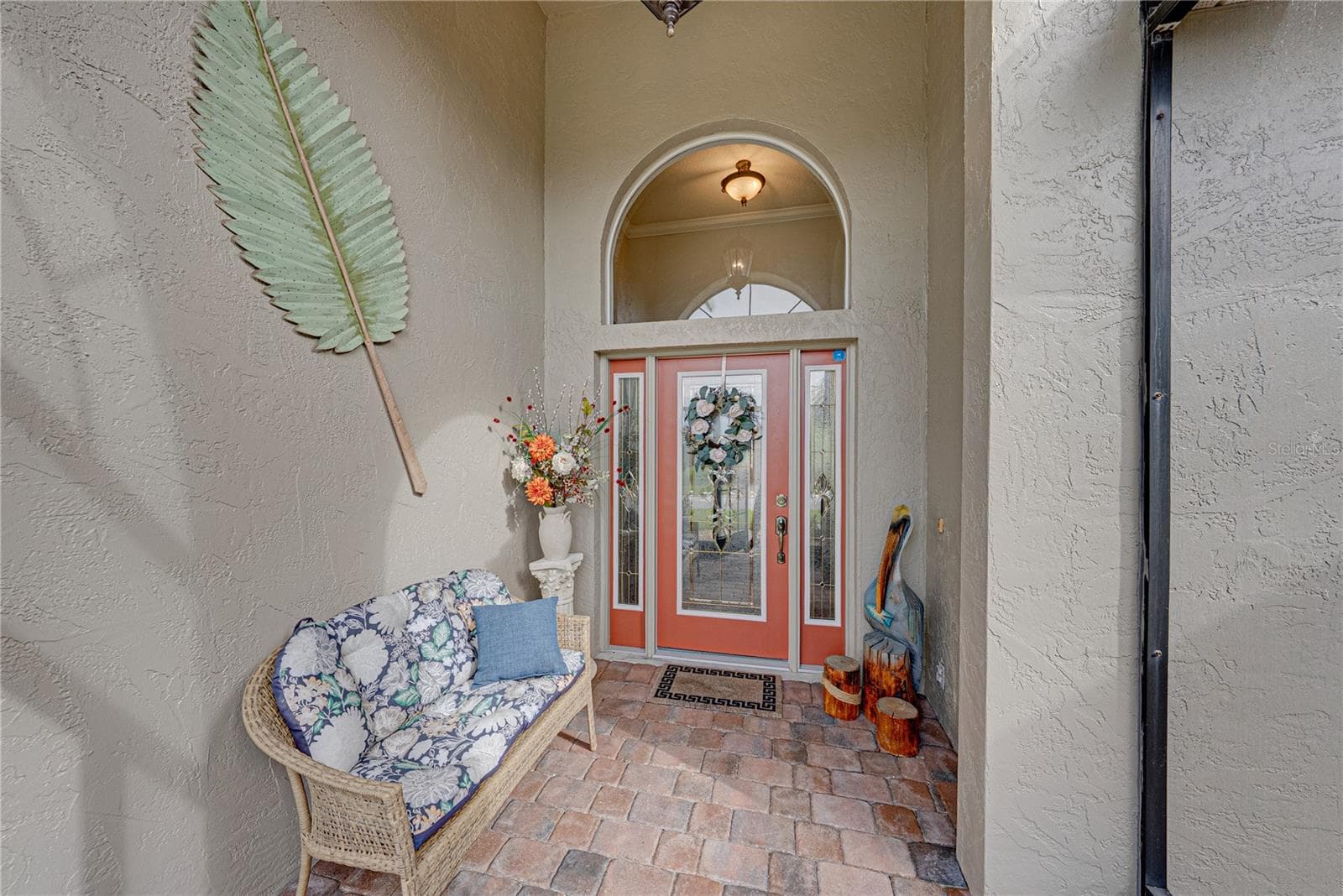 The leaded glass front door and sidelights and the large over the transom arched window provides great natural light to the welcoming foyer. - 4232 DORNOCH DR, LAKE WALES