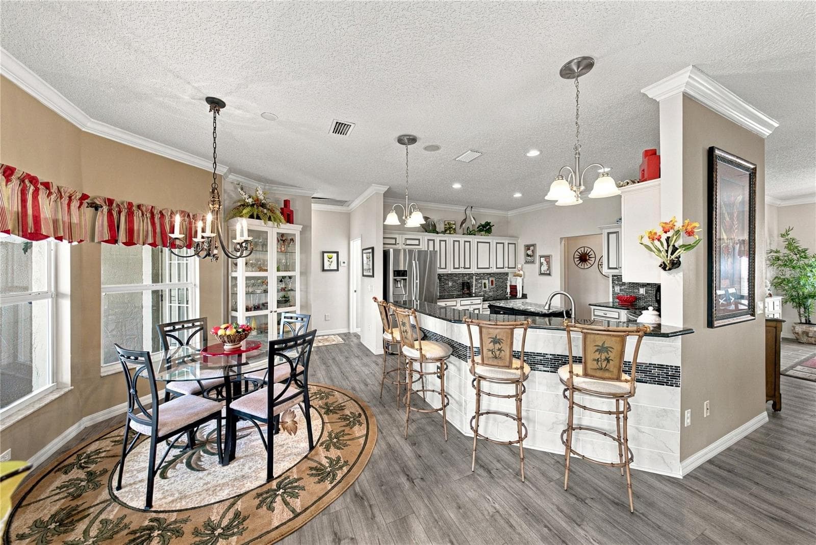 The kitchen features an elevated snack bar. The tile with accent on the snack bar wall adds beauty. - 4232 DORNOCH DR, LAKE WALES