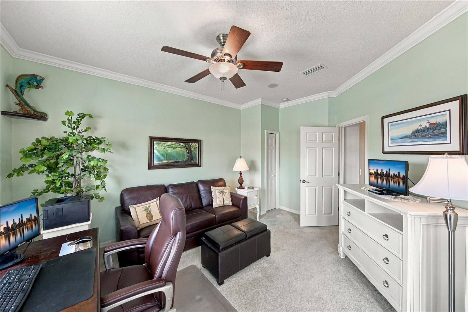 The third bedroom has a closet, crown molding, a custom ceiling fan with light, and is adjacent to the guest bath. - 4232 DORNOCH DR, LAKE WALES