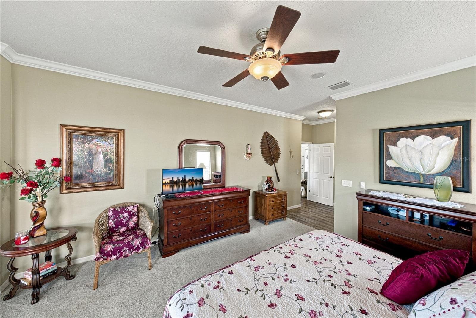 The primary bedroom has a designer ceiling fan with light, crown molding, and quality carpeting. - 4232 DORNOCH DR, LAKE WALES