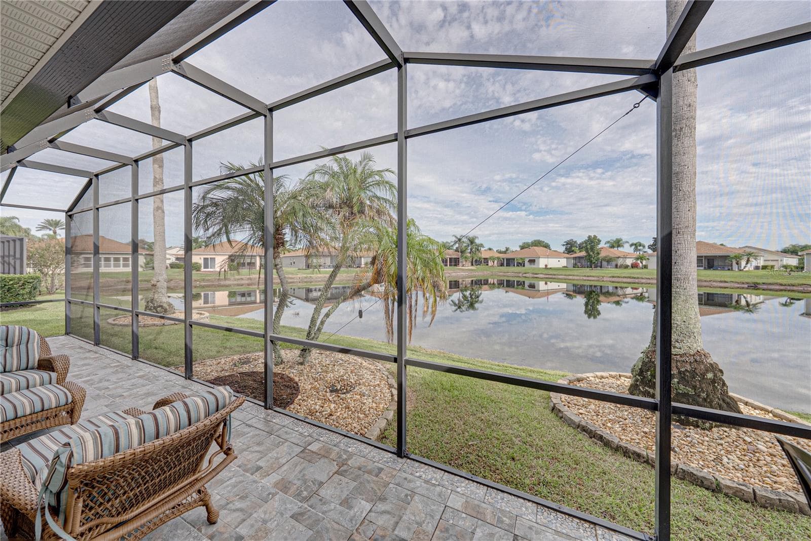 The palms, landscaping, and pond view set this home appart. - 4232 DORNOCH DR, LAKE WALES