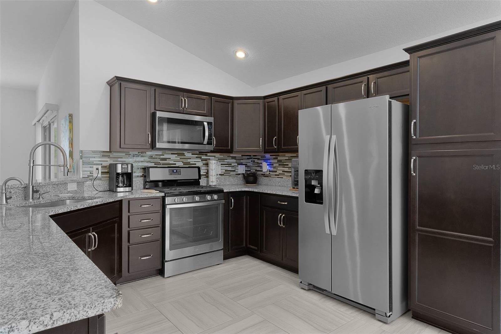 Stainless steel appliances, espresso color cabinets with hardware & backsplash & pantry cabinet - 3144 ROBBS RD, THE VILLAGES
