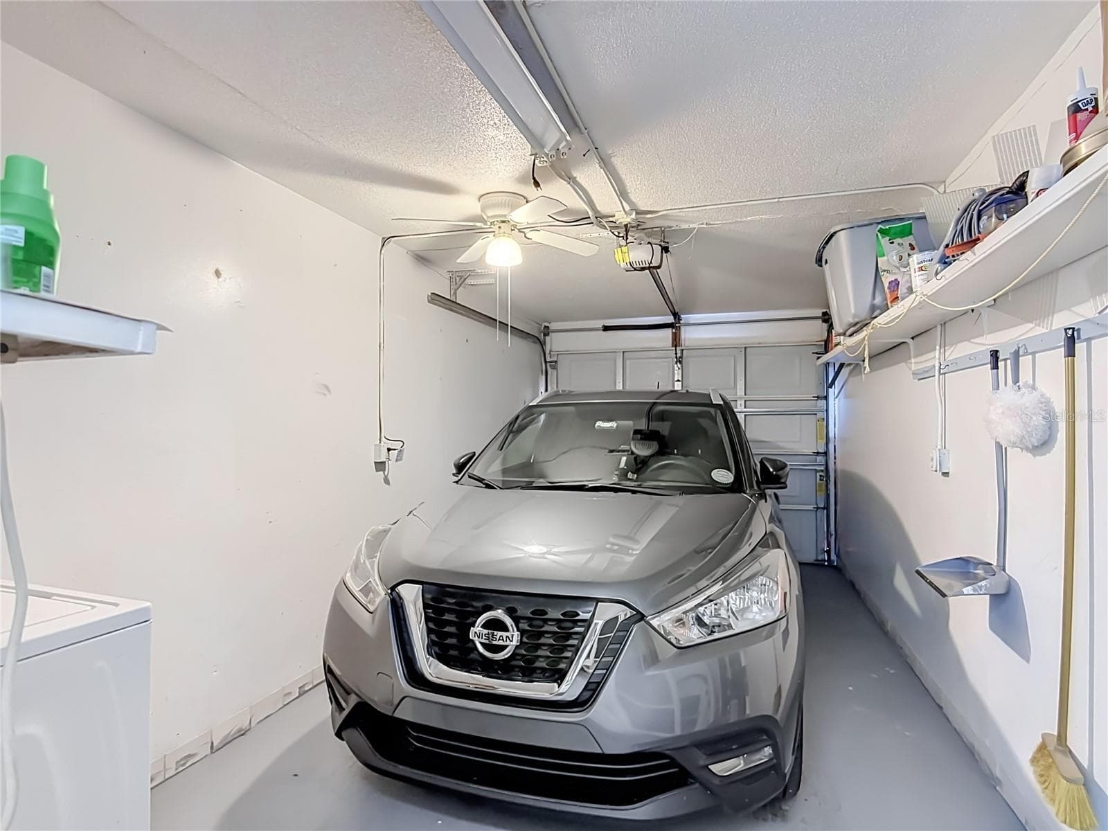 One-car garage with shelving. - 1106 SPRING MEADOW DR, KISSIMMEE