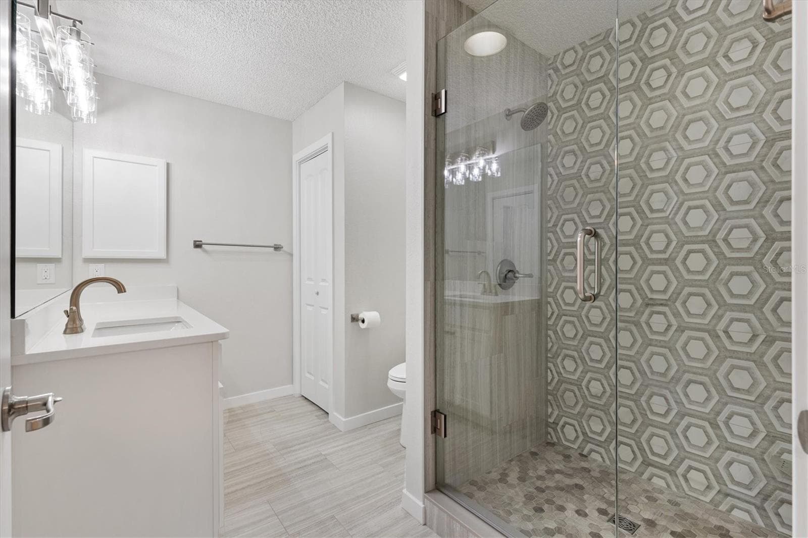Glass Door shower and Quartz countertops enhance the Primary Ensuite. - 9595 SE 171ST ARGYLL ST, THE VILLAGES