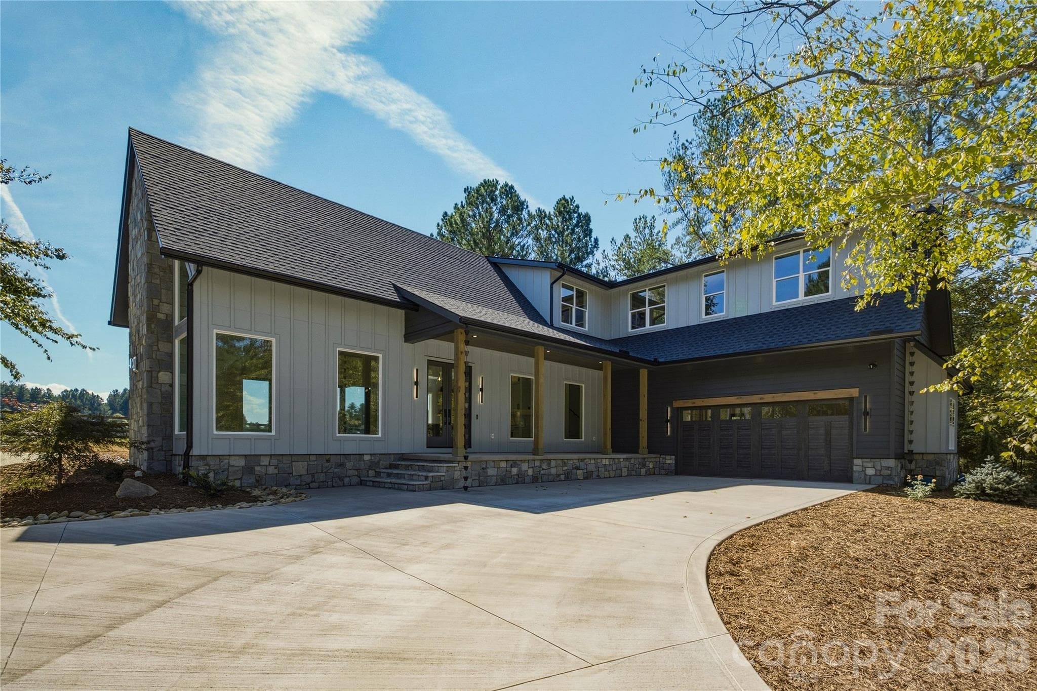 The wood accents on the front porch add a very natural feel to the entry of the home and the carraige house style garage door opens up to an oversized place to park your vehicles. - 2303 Paddock Circle, Morganton