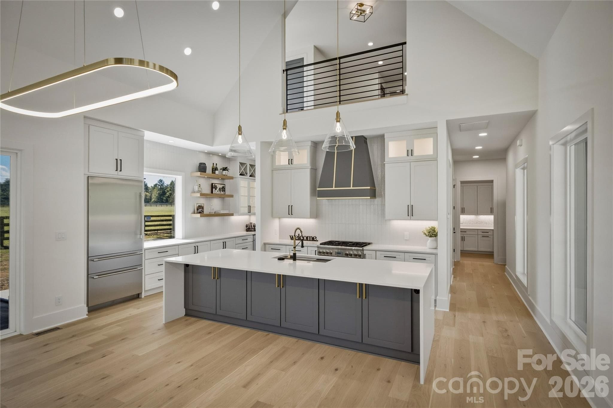 The quartz countertops and the modern light fixtures set the stage. The island has a modern waterfall countertop.  There is even cabinetry tucked under the overhang of the island for a bit of extra storage. - 2303 Paddock Circle, Morganton