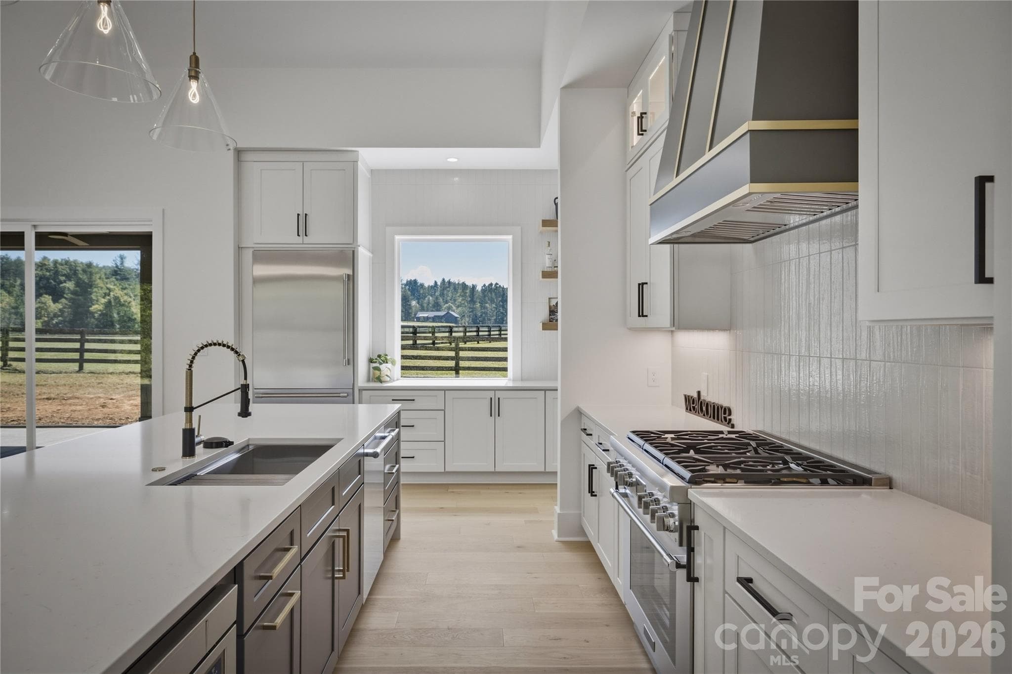 There is a contemporary sink and faucet located on the islandm abd the stainless panelled Thermador refrigerator is built into the cabinetry for a high end look. - 2303 Paddock Circle, Morganton