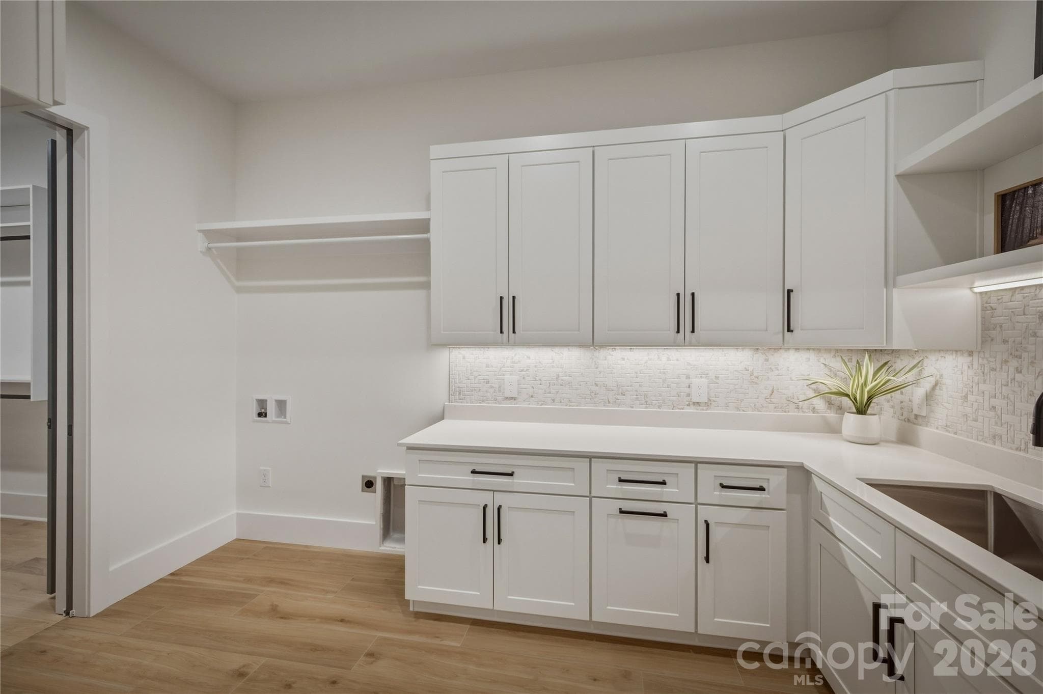 The laundry and mudroom are located conveniently through a doorway in the owners' closet. There are tons of cabinets and a large sink. - 2303 Paddock Circle, Morganton