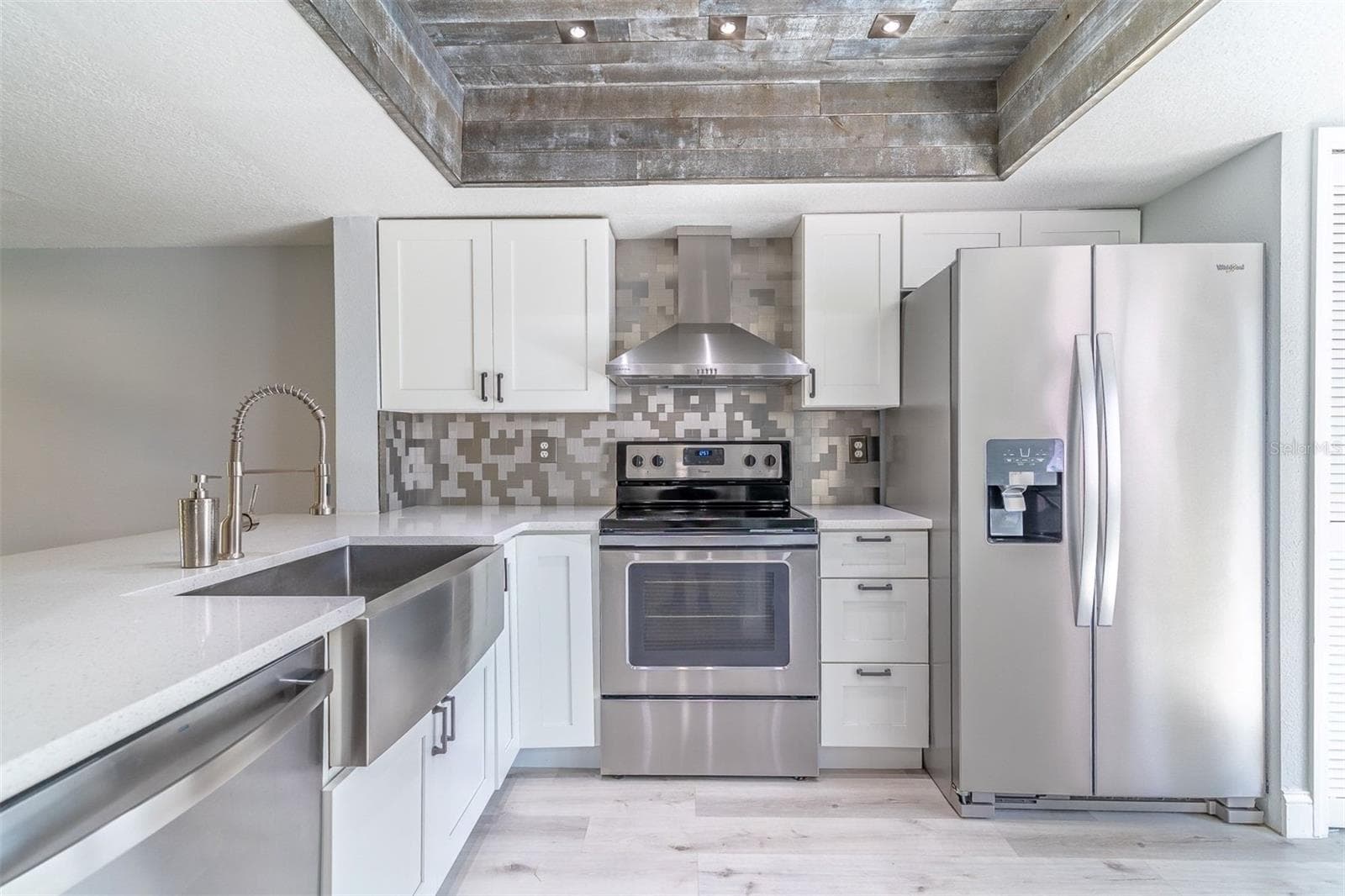 Not your builder-grade kitchen. Featuring custom all-wood shaker cabinetry, an oversized stainless farm sink, and a striking 3D stainless steel backsplash. - 139 OLIVE TREE CIR, ALTAMONTE SPRINGS