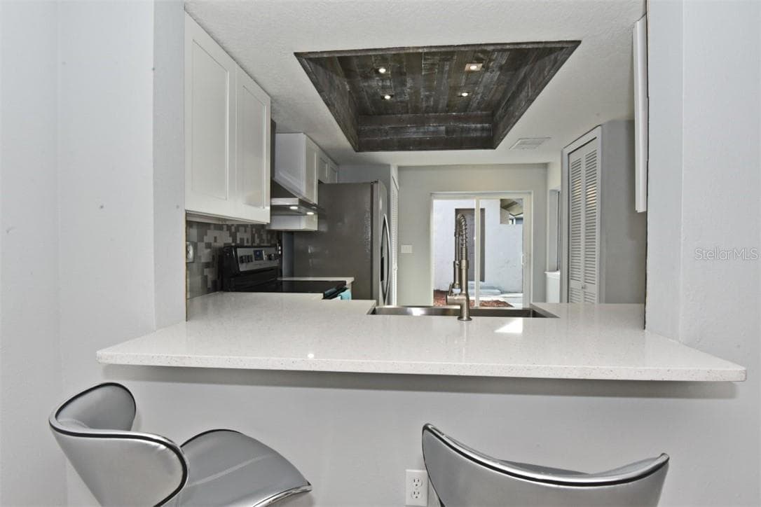 White quartz countertop with an extended bar top that connects the kitchen straight to the living area. - 139 OLIVE TREE CIR, ALTAMONTE SPRINGS