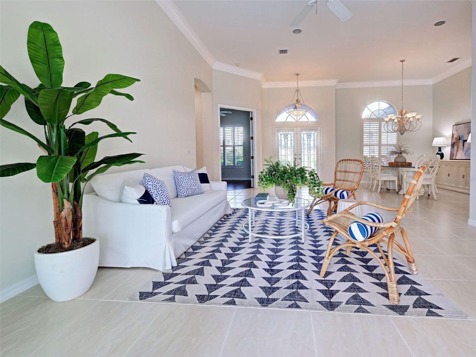 Another view of the great room and dining room.  The over-sized tiles, crown molding, plantation shutters and transom windows make the home so elegant. - 692 EGRET WALK LN, VENICE