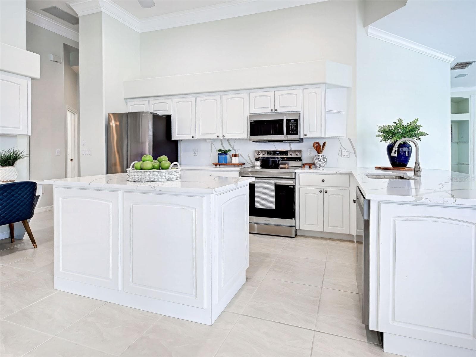 Professionally remodeled kitchen will thrill the cook thanks to the prep island and stunning quartz countertops with waterfall feature. - 692 EGRET WALK LN, VENICE