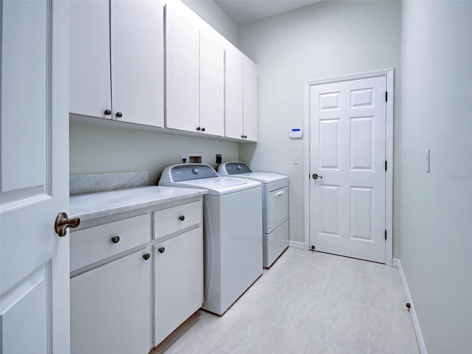 Interior laundry room conveniently leads from the garage to kitchen and has storage and laundry tub - 692 EGRET WALK LN, VENICE