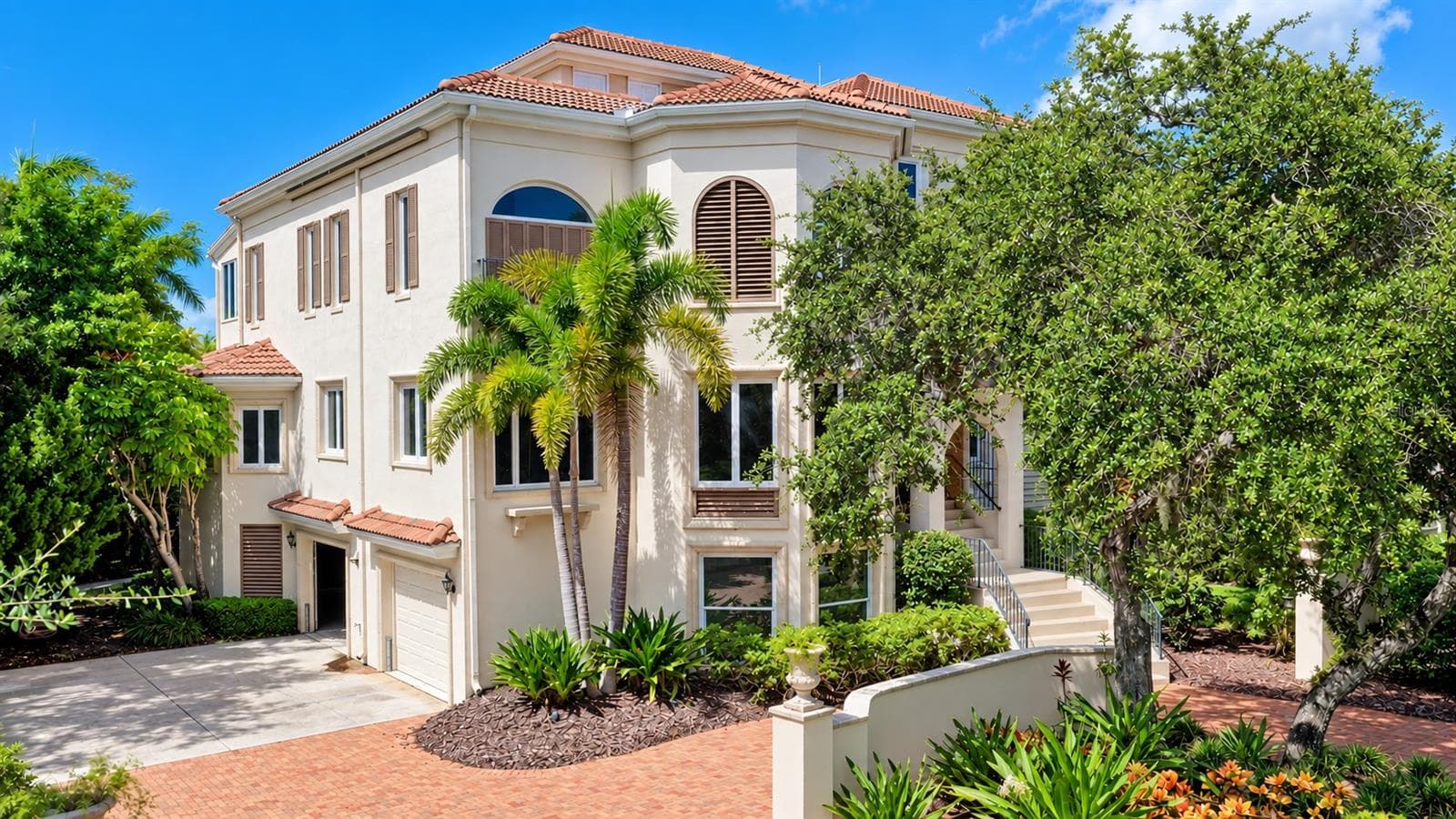 Graceful arched windows, a tile roof and distinctive architectural details give the residence its signature Mizner inspired style. - 168 COASTAL HAMMOCK CT, OSPREY