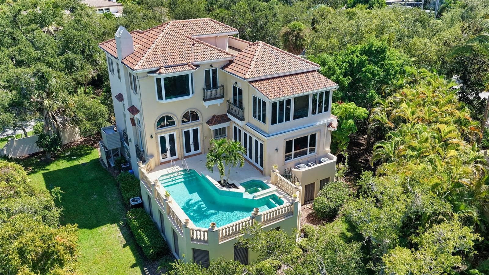 An aerial perspective reveals the home's exceptional privacy, elevated pool terrace and lush natural surroundings. - 168 COASTAL HAMMOCK CT, OSPREY