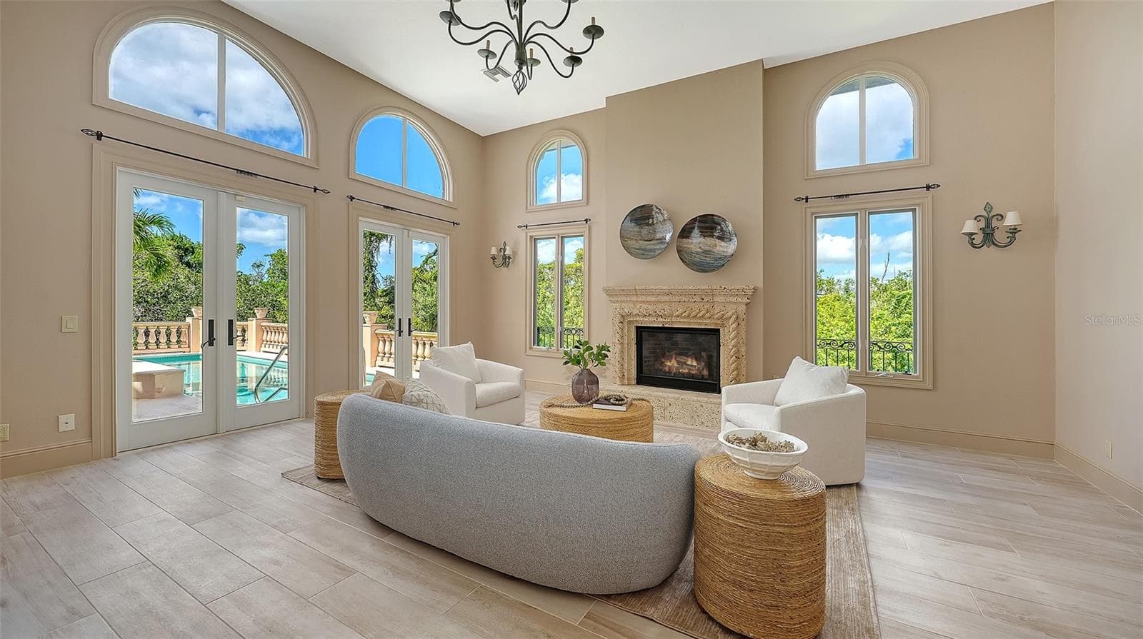 Walls of windows and French doors fill the great room with natural light while connecting the interior to the surrounding landscape. - 168 COASTAL HAMMOCK CT, OSPREY