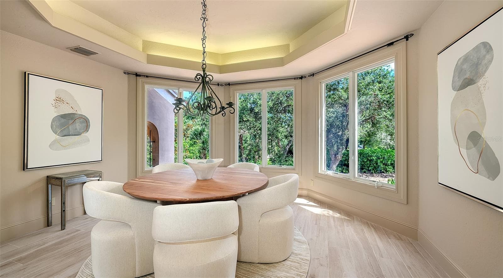 A beautifully defined dining room offers an intimate setting enhanced by a tray ceiling, chandelier and abundant natural light. - 168 COASTAL HAMMOCK CT, OSPREY