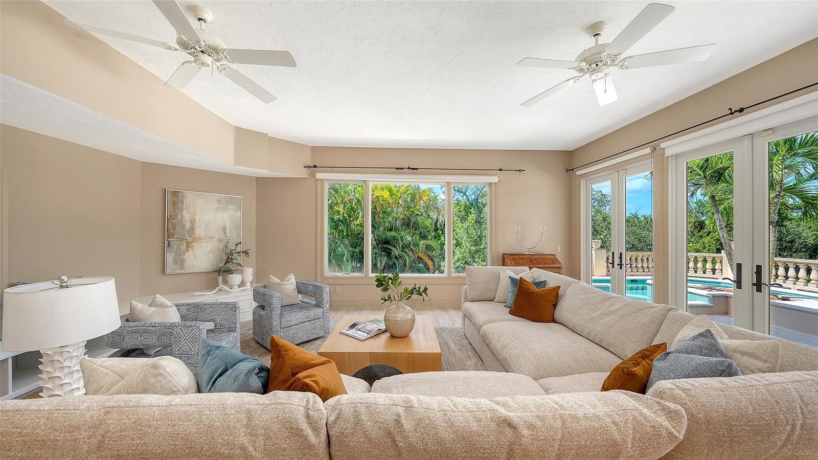 Expansive windows and French doors surround this comfortable gathering space with views of the lush tropical setting. - 168 COASTAL HAMMOCK CT, OSPREY