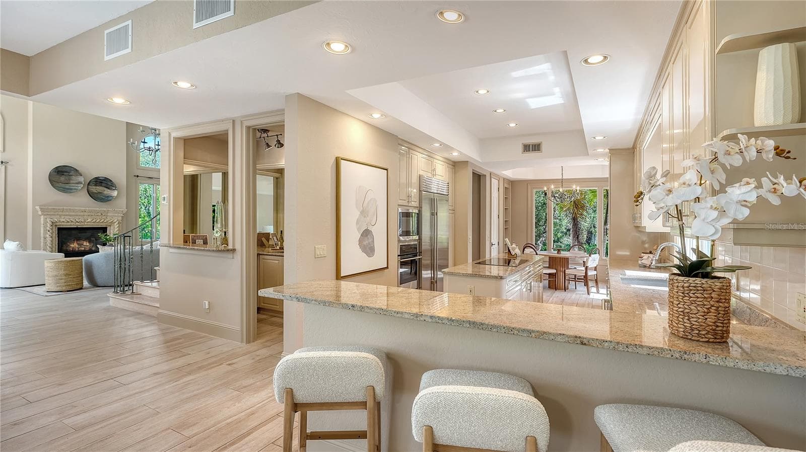 An expansive counter provides abundant workspace and casual seating while connecting the kitchen to the heart of the home. - 168 COASTAL HAMMOCK CT, OSPREY