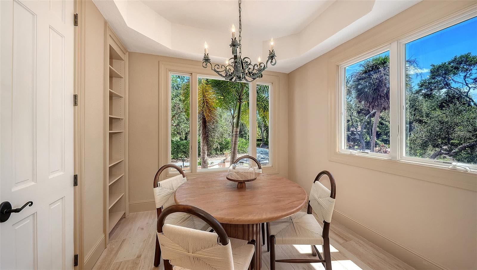 Surrounded by windows and greenery, this intimate dining nook offers a peaceful setting for casual meals. - 168 COASTAL HAMMOCK CT, OSPREY
