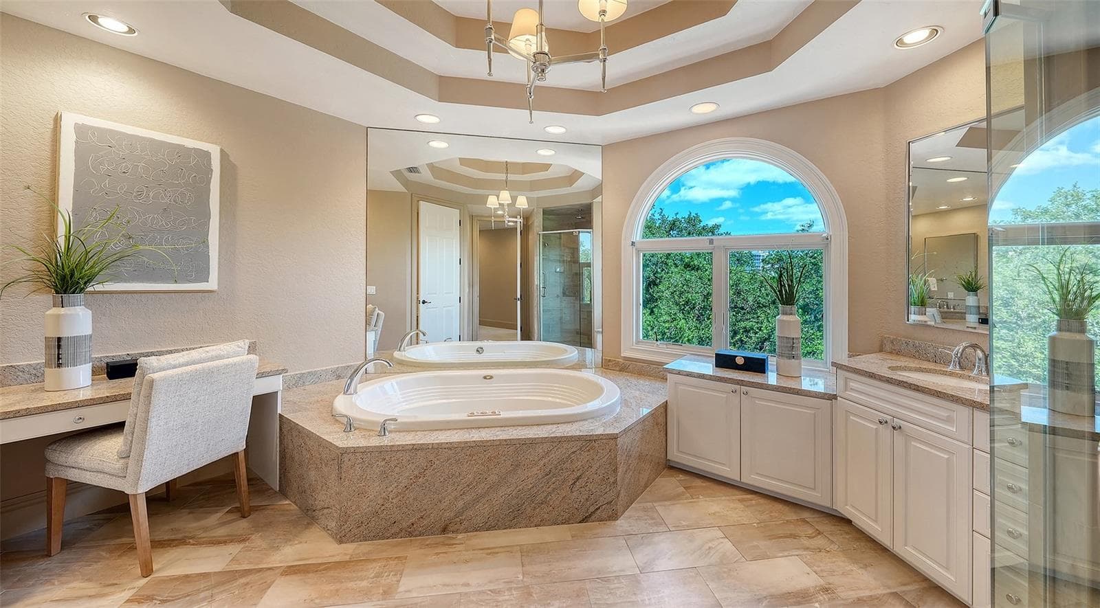 A soaking tub, generous vanity space and graceful architectural detailing create an elegant primary bath. - 168 COASTAL HAMMOCK CT, OSPREY