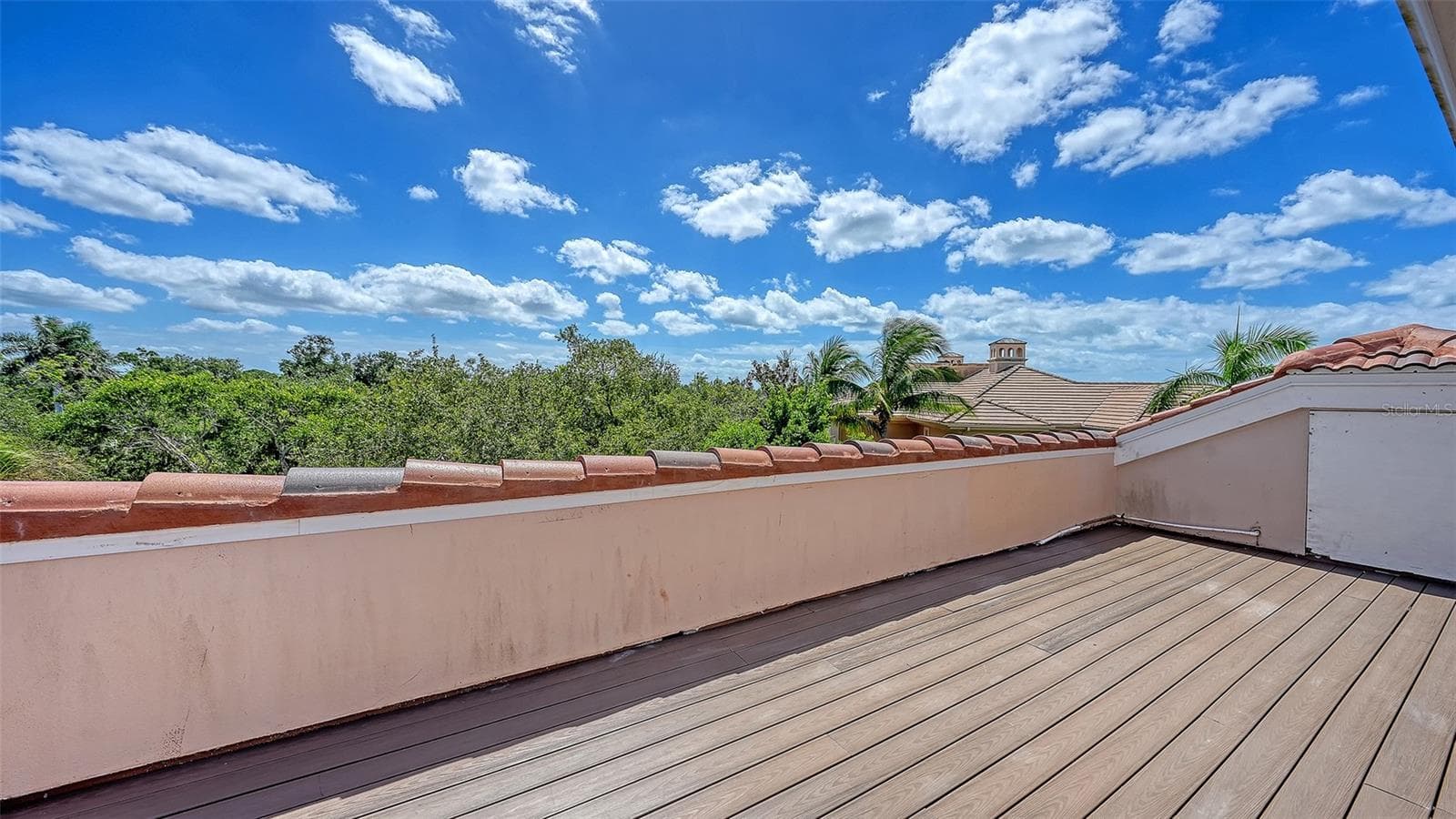 An expansive rooftop terrace creates a remarkable outdoor vantage point above the surrounding treetops. - 168 COASTAL HAMMOCK CT, OSPREY