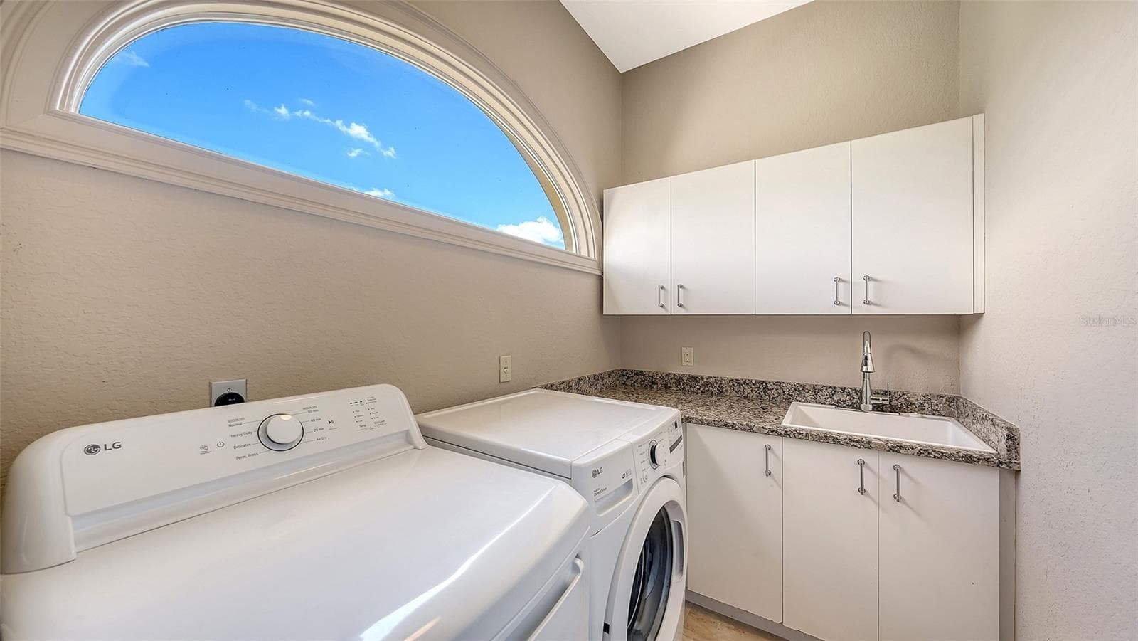 A private laundry area with cabinetry and workspace adds convenience to the primary suite level. - 168 COASTAL HAMMOCK CT, OSPREY