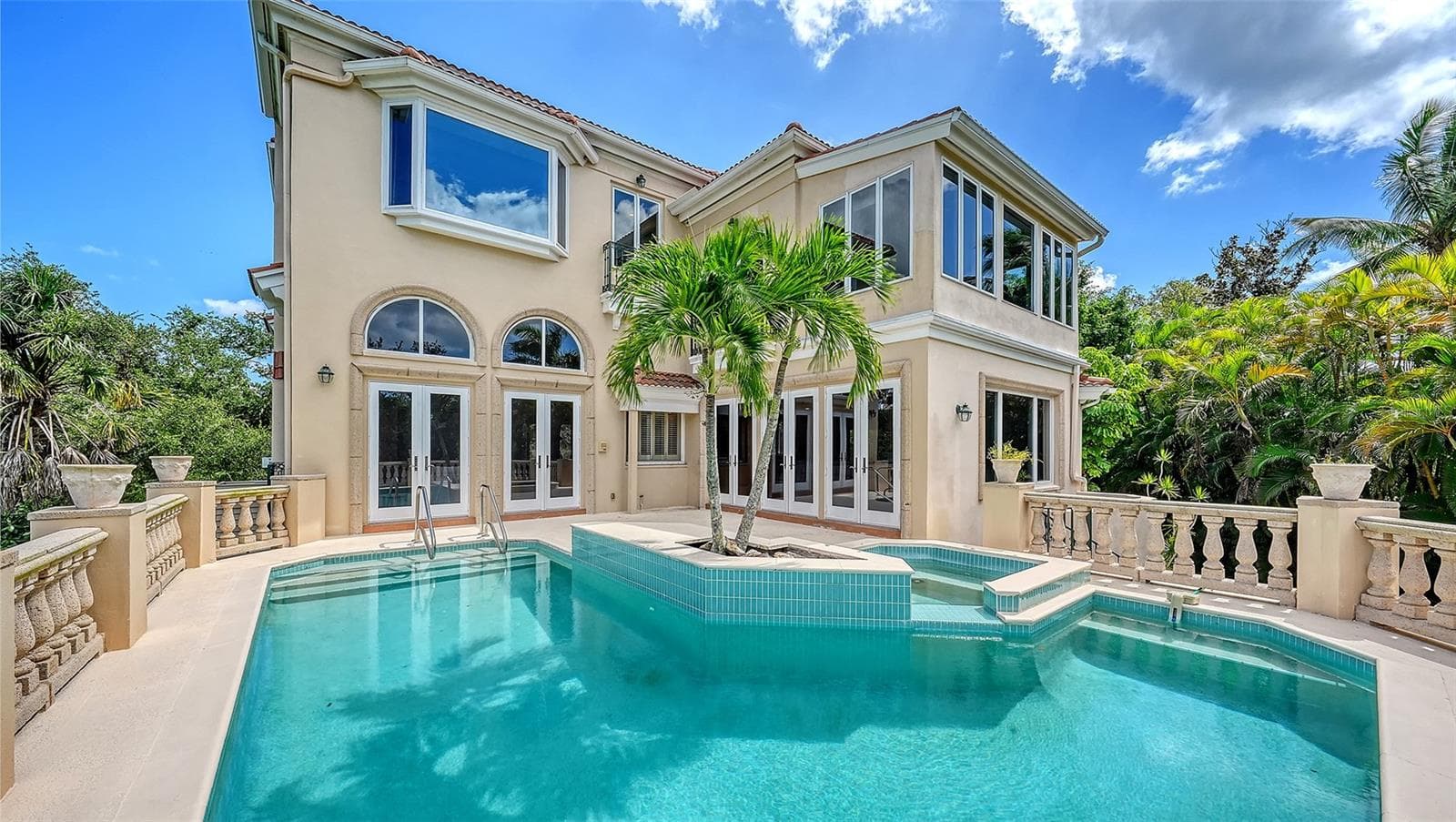 French doors open directly to the pool terrace, seamlessly connecting the home with its private outdoor setting. - 168 COASTAL HAMMOCK CT, OSPREY