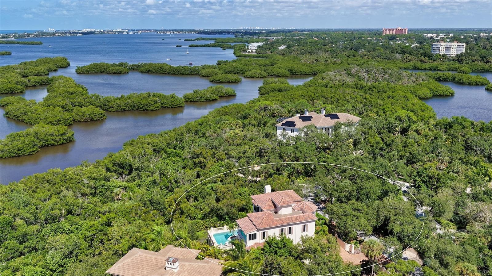The residence is embraced by mature vegetation and the waterways surrounding Little Sarasota Bay. - 168 COASTAL HAMMOCK CT, OSPREY
