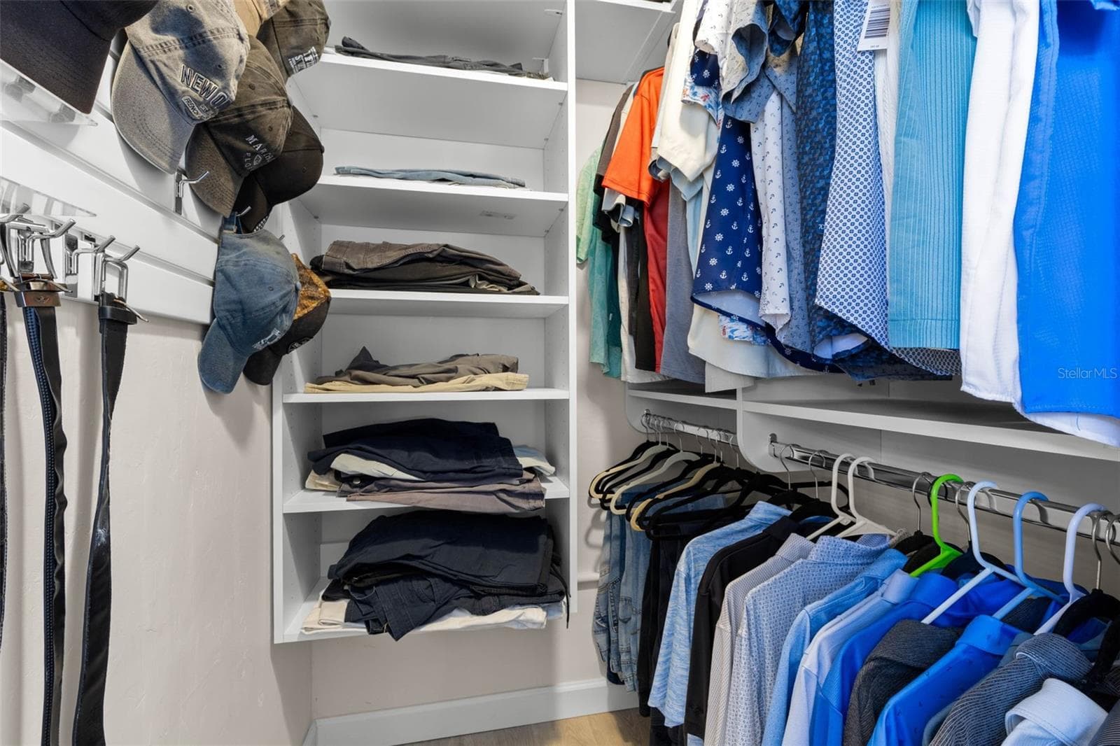 A well-organized walk-in closet in the primary suite offers built-in shelving, double hanging space, and plenty of room to keep clothing and accessories neatly arranged. - 332 WESTWINDS DR, PALM HARBOR
