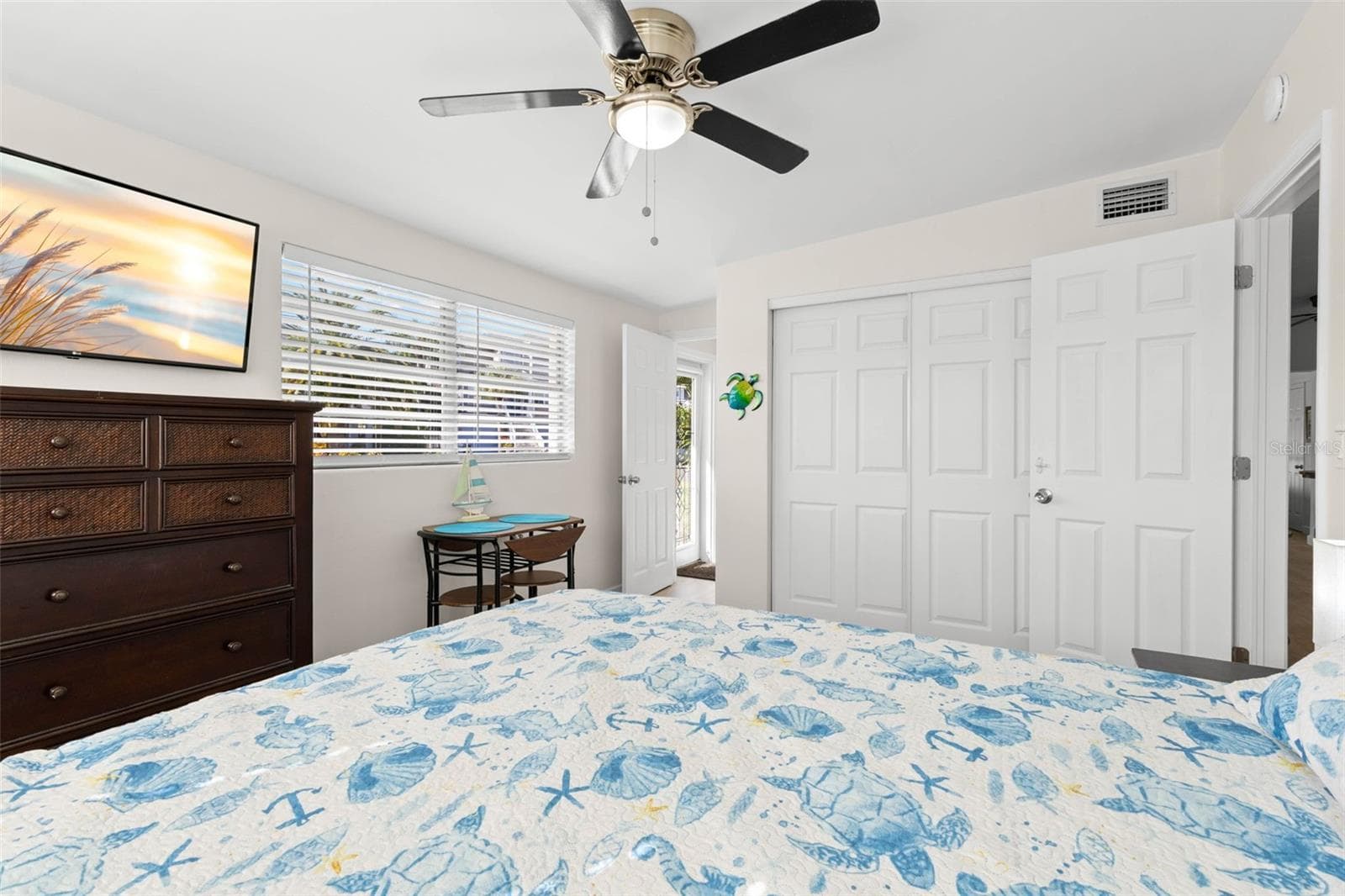 The third bedroom includes a wide closet, large window, ceiling fan, neutral finishes, and luxury vinyl plank flooring (2025), with plenty of room for additional furniture or a small sitting area. - 332 WESTWINDS DR, PALM HARBOR