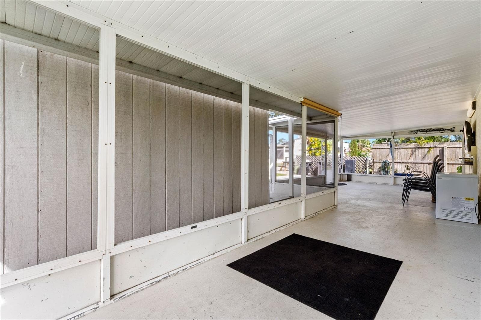 The spacious screened lanai offers a long stretch of covered outdoor living space with plenty of room for dining, lounging, and gathering while staying shaded from the Florida sun. - 332 WESTWINDS DR, PALM HARBOR