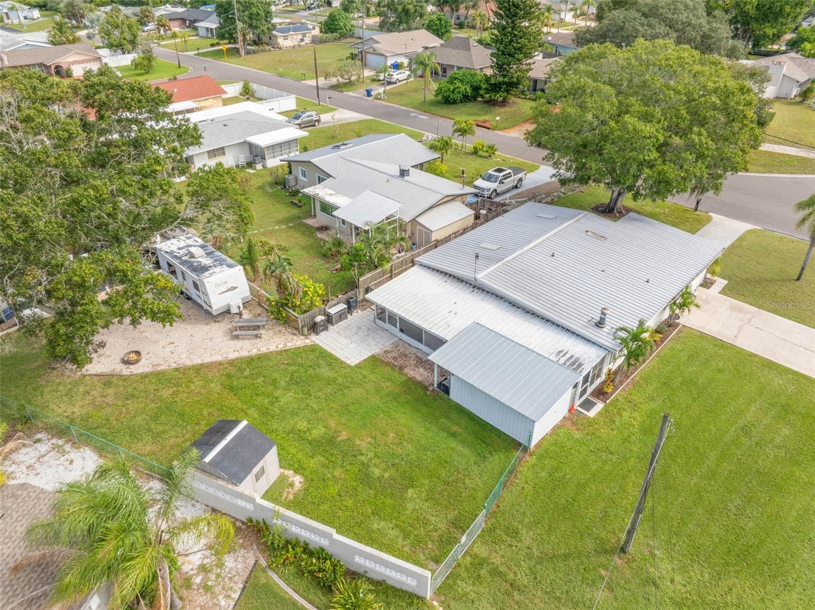 An aerial view shows just how much this property offers, with a broad backyard, RV parking area, screened lanai, workshop/storage space, and plenty of room to spread out. - 332 WESTWINDS DR, PALM HARBOR