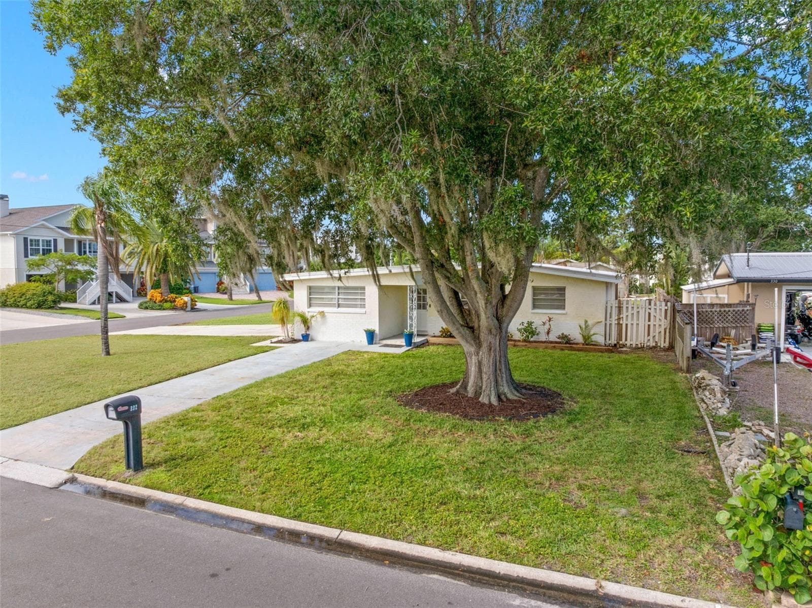 magnificent mature oak anchors the broad front lawn, while the home’s corner setting creates a wonderful sense of space and separation from neighboring properties. - 332 WESTWINDS DR, PALM HARBOR