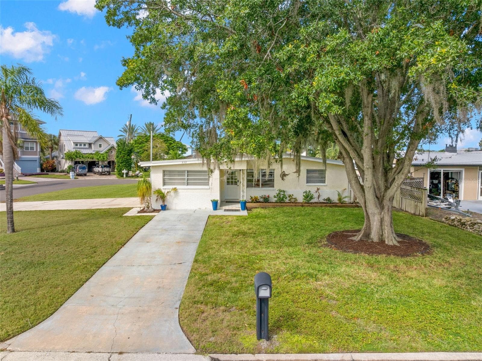 Set on a generous 11,800-square-foot corner property at the end of a cul-de-sac, the home enjoys a broad front lawn, mature shade tree, and plenty of breathing room from the street. - 332 WESTWINDS DR, PALM HARBOR