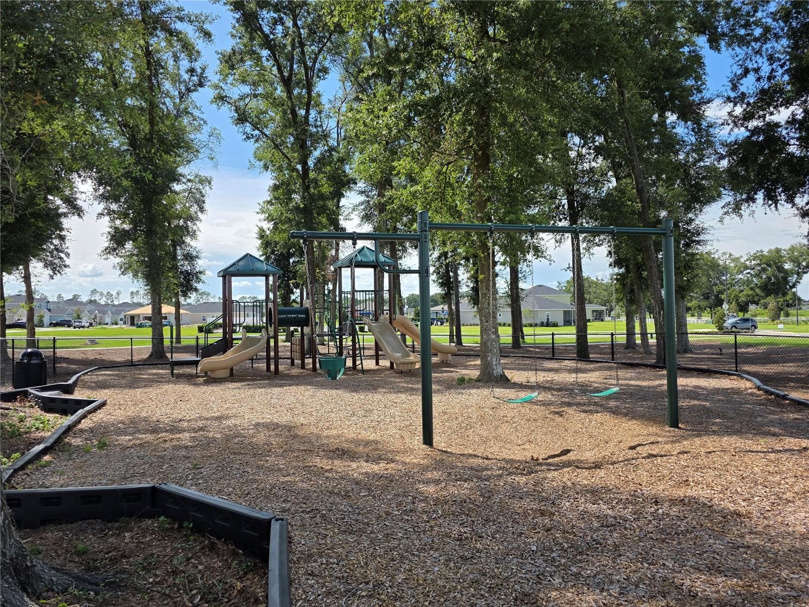 Fully fenced playground for outdoor fun with swings and more. This is located among the shade trees. - 4745 SW 83RD LOOP, OCALA
