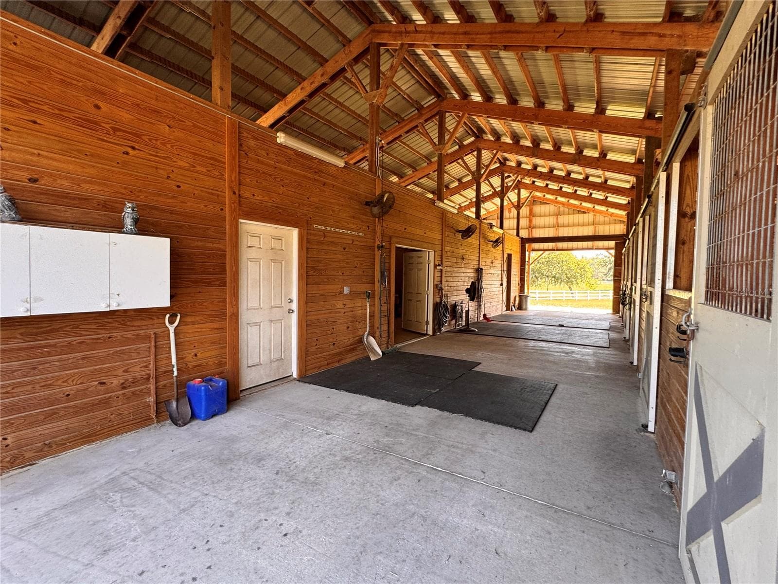 Spacious center aisle barn with dedicated tack room and feed areas - 6722 W SENTINEL BLUFF PATH, BEVERLY HILLS