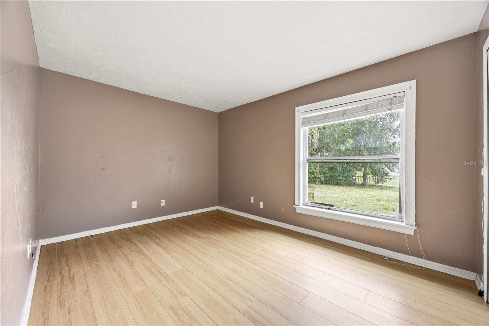 This third bedroom is spacious with laminated flooring. Window view. - 3906 SANTIAGO ST, SEBRING